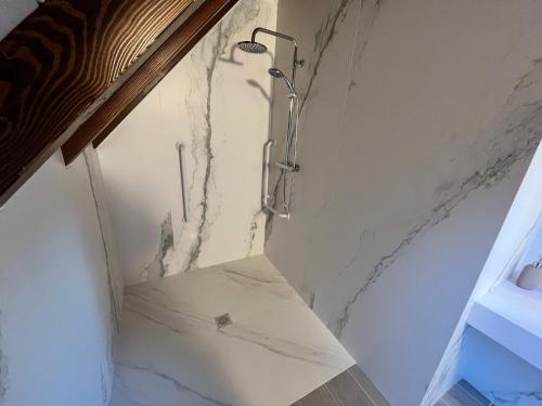 a shower in a bathroom with a marble wall at HOTEL RURAL BASQUE IRATI in Espinal-Auzperri