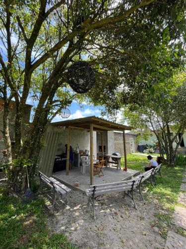 a gazebo with a table and chairs under a tree at Pousada Guaricana in Pontal do Paraná