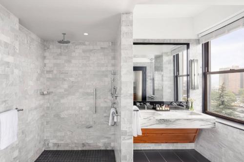a bathroom with a large shower and a tub at The Press Hotel, Autograph Collection in Portland