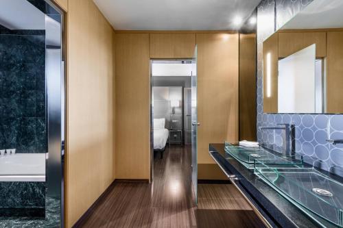 uma casa de banho com um balcão de vidro e uma banheira em AC Hotel A Coruña by Marriott em La Coruña