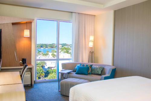 a hotel room with a bed and a chair and a window at Courtyard by Marriott Fort Walton Beach-West Destin in Fort Walton Beach