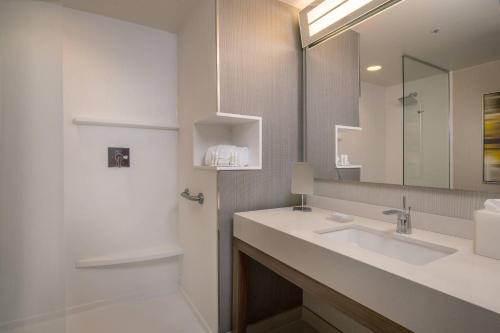 a bathroom with a sink and a mirror and a shower at Courtyard by Marriott Fort Walton Beach-West Destin in Fort Walton Beach