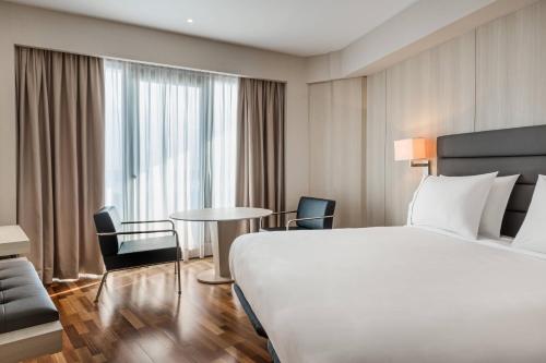 a hotel room with a bed and a table and chairs at AC Hotel Gran Canaria by Marriott in Las Palmas de Gran Canaria