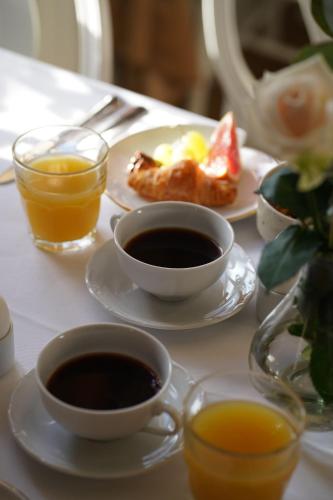 a table with plates of food and cups of coffee at Hennickehammars Herrgård in Filipstad