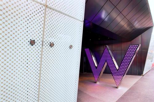 a purple sign that says w on a wall at W London in London