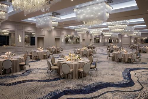 a banquet hall with tables and chairs and chandeliers at JW Marriott Savannah Plant Riverside District in Savannah