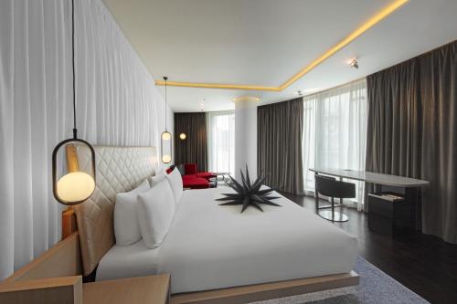 ロンドンにあるW Londonの白いベッドとデスクが備わるホテルルームです。