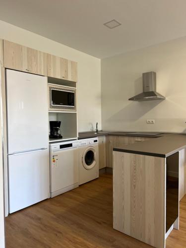 Una cocina con un frigorífico blanco y un lavavajillas. en Costa Santander. Apartamento con jardín, en Santander