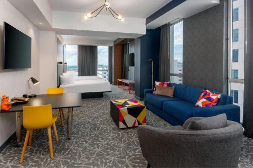 a living room with a blue couch and a table at Aloft Orlando Downtown in Orlando