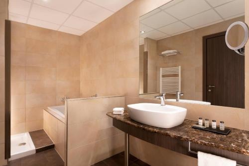 a bathroom with a sink and a mirror at Sheraton Milan Malpensa Airport Hotel & Conference Centre in Ferno