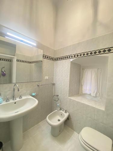 bagno bianco con lavandino e servizi igienici di Ilia a Lerici