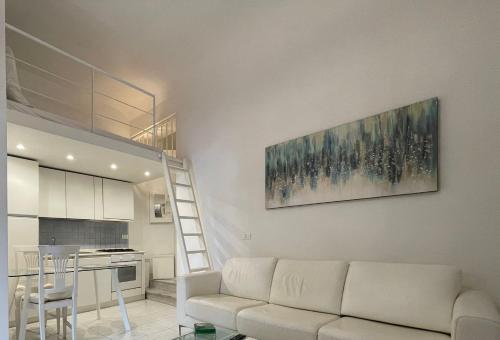 un soggiorno con divano bianco e una cucina di Ilia a Lerici