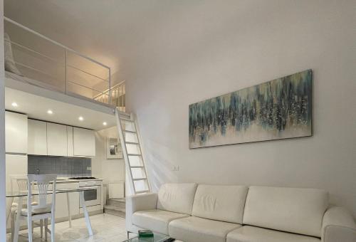 a living room with a white couch and a kitchen at Ilia in Lerici