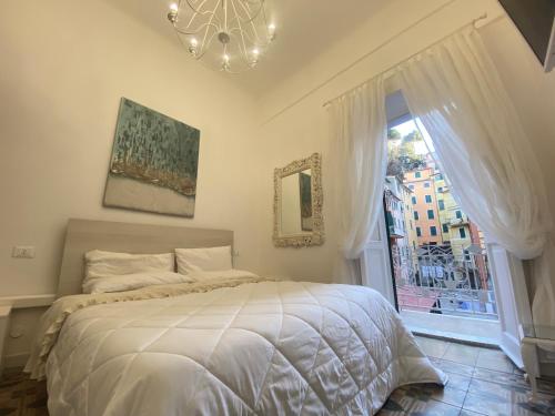 una camera con letto, finestra e lampadario a braccio di Ilia a Lerici
