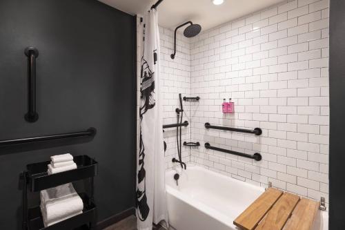 a bathroom with a white tub and a shower at MOXY Memphis Downtown in Memphis