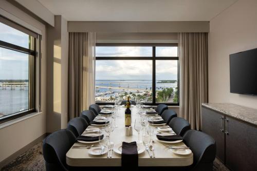a long dining room with a long table and chairs at Luminary Hotel & Co., Autograph Collection in Fort Myers