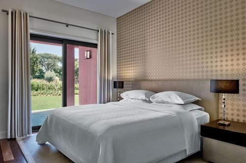 منتجع شيراتون كاسكايس - فندق وسكن في كاسكايس: غرفة نوم بسرير ابيض ونافذة كبيرة