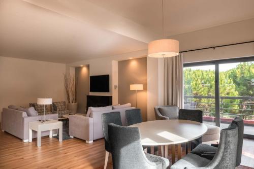 ein Wohnzimmer mit einem Tisch und Stühlen in der Unterkunft Sheraton Cascais Resort - Hotel & Residences in Cascais
