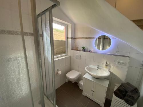 ein weißes Bad mit einem Waschbecken und einem WC in der Unterkunft Ferienwohnung "Seeperle" Marina Mücheln Geiseltalsee in Mücheln