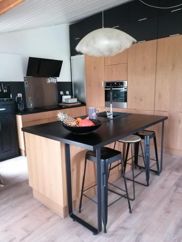 une cuisine avec une table avec un bol de fruits dessus dans l'établissement maison bois, à Ruaudin
