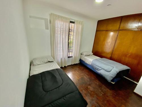 Barraquero的住宿－Vivi Mendoza，小房间设有两张床和窗户