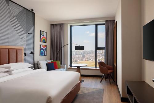 a hotel room with a bed and a large window at Sheraton Istanbul Esenyurt in Istanbul