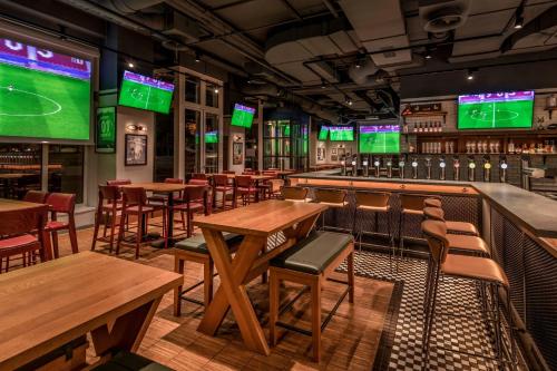 a bar with tables and chairs and televisions at Vienna Marriott Hotel in Vienna