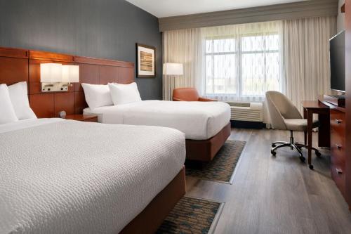 a hotel room with two beds and a desk at Courtyard by Marriott Scottsdale Salt River in Scottsdale