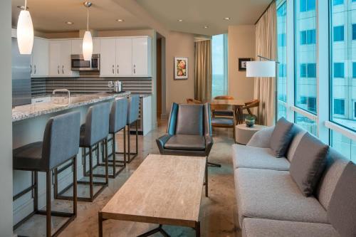 a living room with a couch and a bar at The Westin Houston, Memorial City in Houston