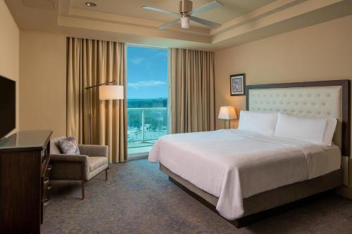 a hotel room with a bed and a chair and a window at The Westin Houston, Memorial City in Houston