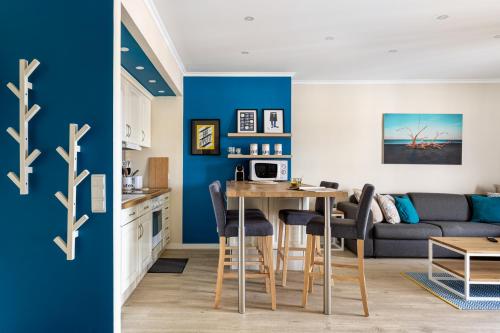 uma cozinha e uma sala de estar com paredes azuis em ALTIDO Stylish flat with balcony overlooking the sea em Costa da Caparica