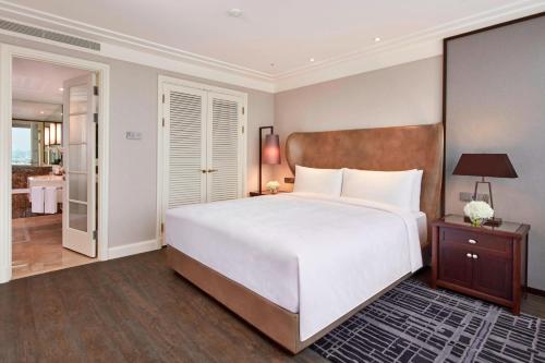 a bedroom with a large white bed and a bathroom at JW Marriott Hotel Seoul in Seoul