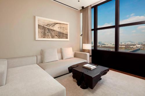 a living room with a couch and a large window at JW Marriott Hotel Seoul in Seoul