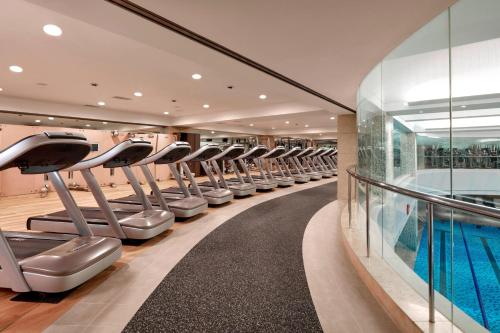 a gym with rows of treadmills and a swimming pool at JW Marriott Hotel Seoul in Seoul