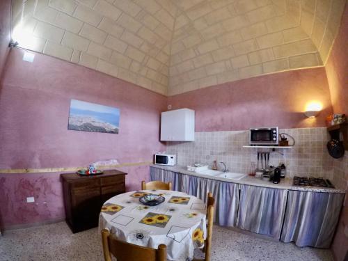 a kitchen with a table with chairs and a counter at Casa Vacanze "Isole e Tramonti" in Marsala
