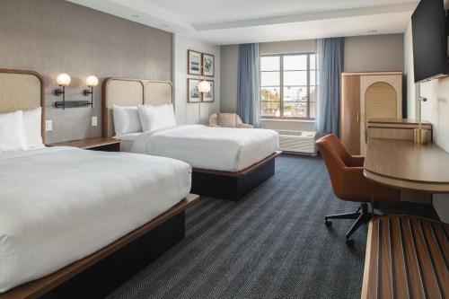 a hotel room with two beds and a desk at Courtyard by Marriott Santa Cruz in Santa Cruz