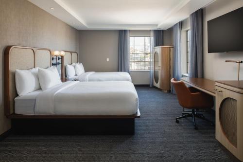a hotel room with two beds and a desk at Courtyard by Marriott Santa Cruz in Santa Cruz