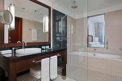 a bathroom with a sink and a shower and a tub at Sheraton Sopot Hotel in Sopot