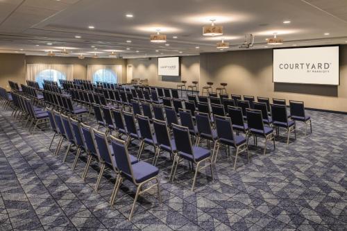 a conference room with chairs and a projection screen at Courtyard by Marriott Santa Cruz in Santa Cruz