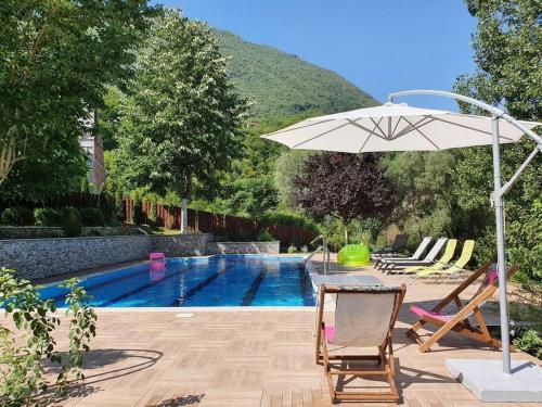 a pool with a table and an umbrella and chairs at Vila Kuća mira in Konjic