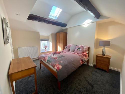 a bedroom with a bed and a table and a window at Mountain Dream Ramsey Isle of Man in Ramsey