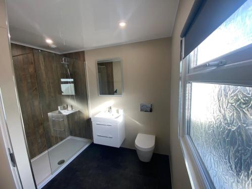 uma casa de banho com um chuveiro, um WC e um lavatório. em Mountain Dream Ramsey Isle of Man em Ramsey