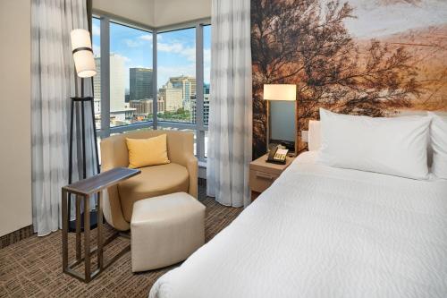 um quarto de hotel com uma cama e uma cadeira e uma janela em Courtyard By Marriott El Paso Downtown/Convention Center em El Paso