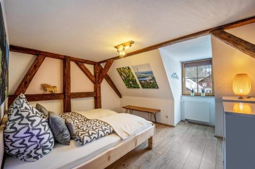 1 dormitorio con 1 cama en una habitación con vigas de madera en Gipfelstürmer en Nesselwang