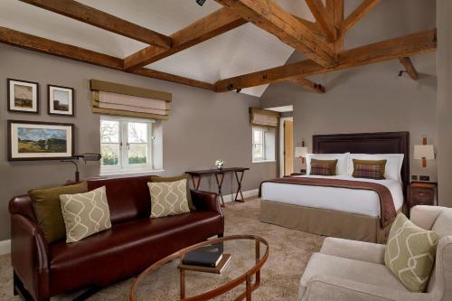 a bedroom with a king sized bed and a couch at The Langley, a Luxury Collection Hotel, Buckinghamshire in Iver