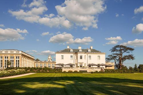 un grand bâtiment blanc avec une grande pelouse dans l'établissement The Langley, a Luxury Collection Hotel, Buckinghamshire, à Iver