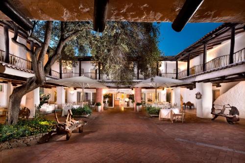 un patio de un hotel con mesas y sombrillas en Cervo Hotel,Costa Smeralda Resort en Porto Cervo