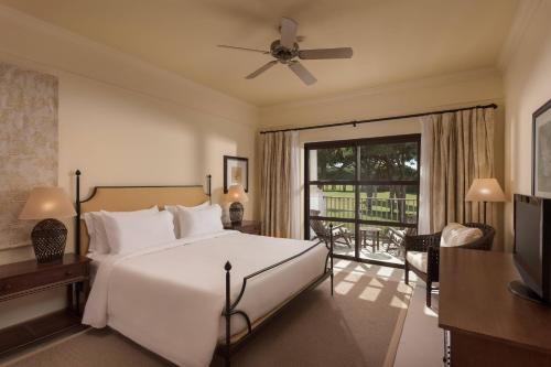 1 dormitorio con 1 cama blanca grande y balcón en Pine Cliffs Residence, a Luxury Collection Resort, Algarve en Albufeira