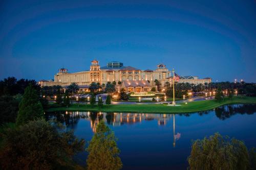 a large building with a lake in front of it at Gaylord Palms Resort & Convention Center in Orlando