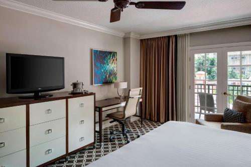 a hotel room with a bed and a desk and a television at Gaylord Palms Resort & Convention Center in Orlando